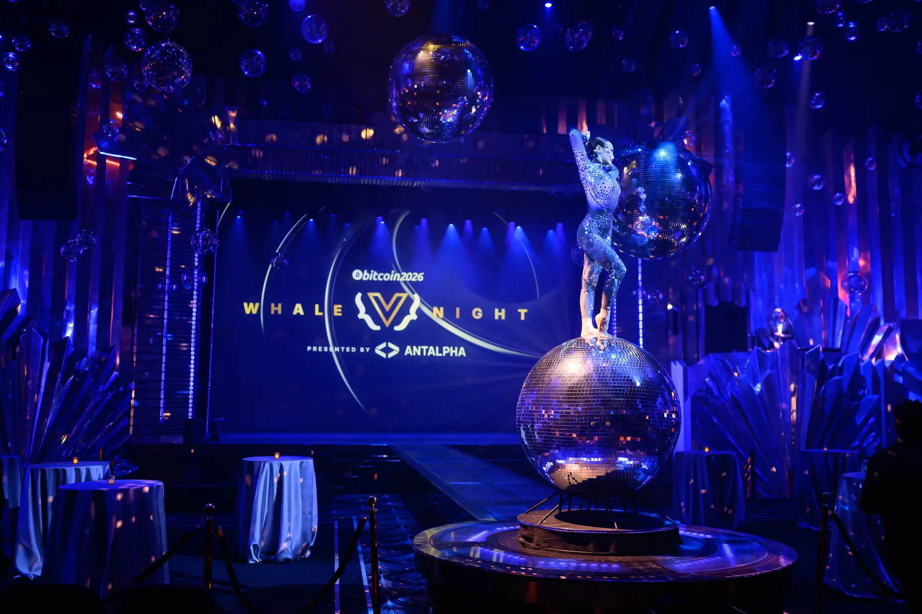 Performer above a mirrored globe on the Whale Night stage
